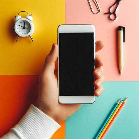 Smartphone mockup in female hands on colorful background, top viewの素材