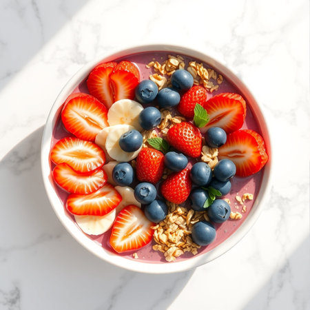 Healthy breakfast bowl with yogurt, berries and granola on white marble tableの素材