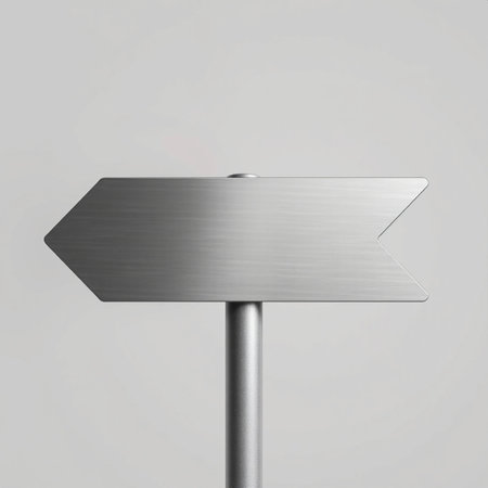 A sleek metallic sign shaped like a left-pointing arrow, mounted on a pole against a light gray background. The brushed texture and clean design evoke modernity and clarity, ideal for navigation or signage themes.の素材