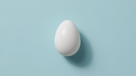 One white egg on blue background. Minimal easter concept.の素材