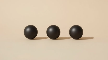Three black balls on a beige background. Minimalism.の素材