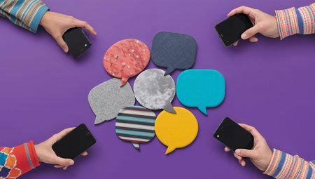 Top view of people hands holding smartphones with blank speech bubbles on color background