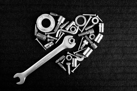 heart of theart of the tools and screw nuts on a dark gray background in black and whiteの写真素材