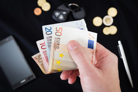 mans hand holding money on the black backgroundの写真素材