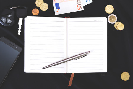 open notebook , phone, money on a black backgroundn notebook on a black backgroundの写真素材