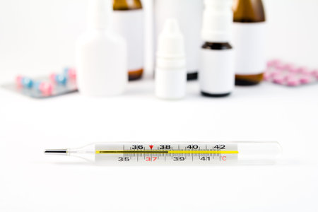Thervometer on white and the medications at the background