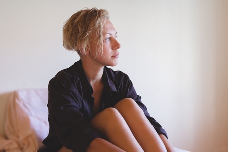 Awesome sexy model with short blonde natural hair, beautiful eyes, full lips, perfect skin posing in man's shirt without make-upの写真素材