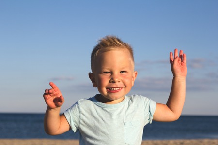 Kid on a beach laughing and playing in sunset lightの写真素材