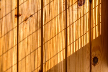 Wooden wall background in a morning light. With shadows from a window frame.の写真素材