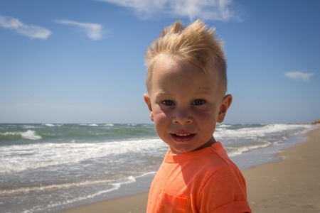 Cute baby boy playing with beach toys on tropical beachの写真素材