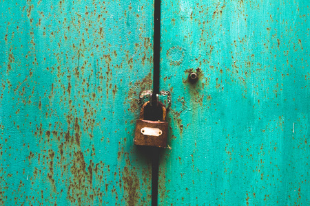 Rusted metal texture closeup photo as a background. Metal door with knob and lockの写真素材