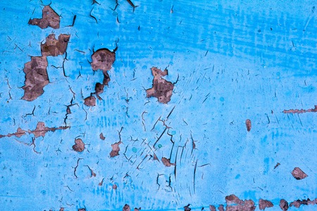 Cracked paint blue background with black and gray spotsの写真素材