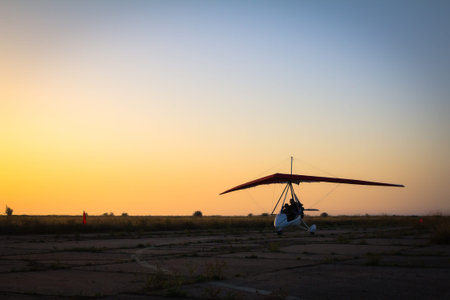 Hang-gliding standing at dawn on the runway, ready for takeoff