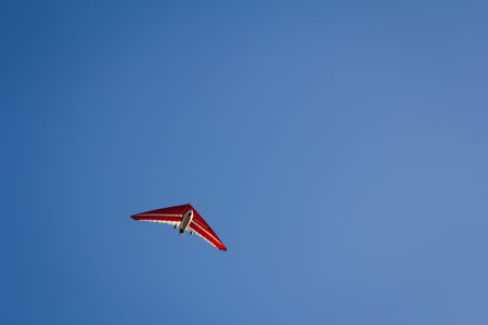 Motorized hang glider soaring in the blue sky in the sun