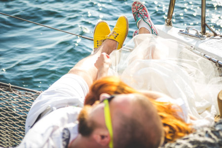 Young couple in love on sail boat at sunset