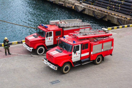 Odesa, UKRAINE - MARCH, 26, 2015: Two firetrucks standing in the sea port on the pier