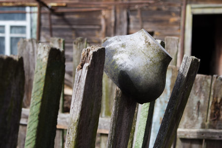 old aluminum pot hanging on a fenceの写真素材