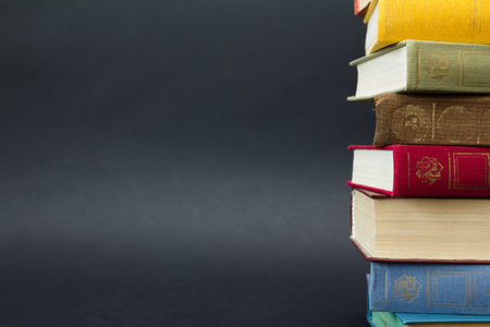 Stack of colorful books, on black background