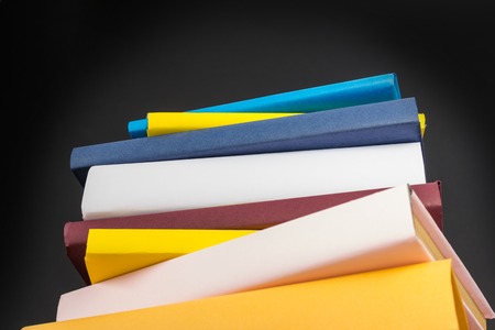 Stack of colorful books, on black backgroundの写真素材