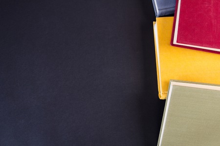 Stack of colorful books, on black backgroundの写真素材