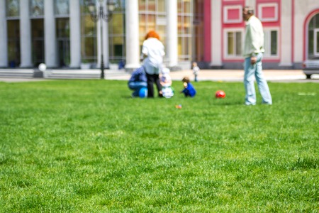 Blured background of people having rest in the park in sunny dayの写真素材