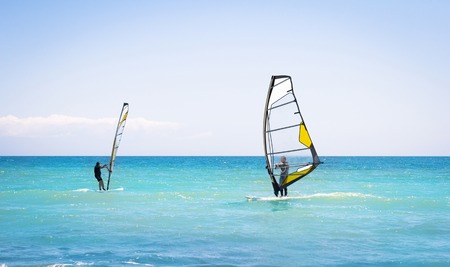 Windsurfing sails on the blue sea riding the windの写真素材