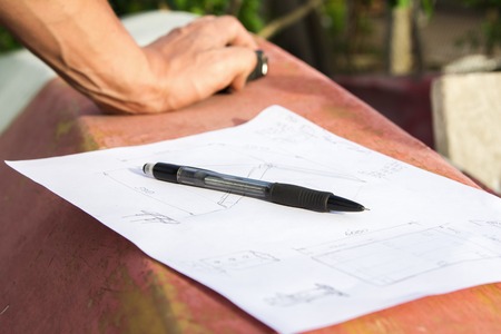 Closeup photo of drawing, pencil and hands of a carpenter who is going to make designの写真素材