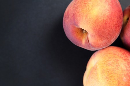 Close up shot of a fresh peach isolated on a black backgroundの写真素材