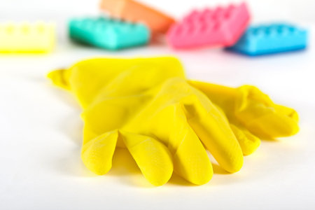 Close up of rubber gloves and sponges over white background. Tpview