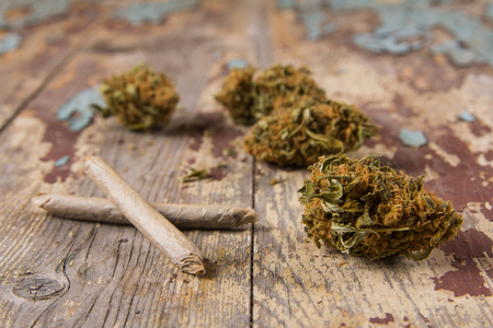 Marijuana buds and joints on the rustic wooden table. Closeupの写真素材