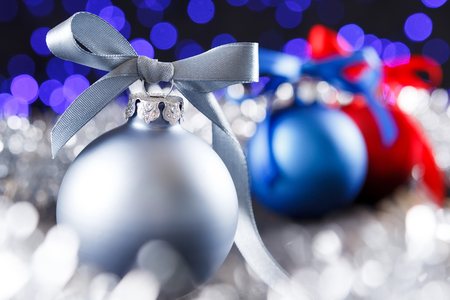 Red christmas ball and blured purple blue and white lights at the backgroundの写真素材