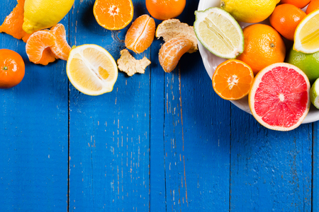 various types of citrus fruit on a blue painted wooden backgroundの写真素材