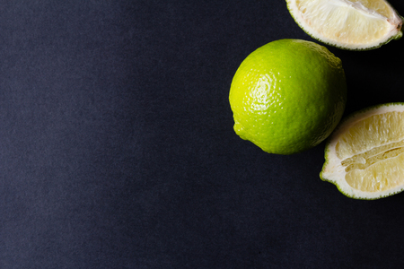 Whole and sliced lime on a dark backgroundの写真素材