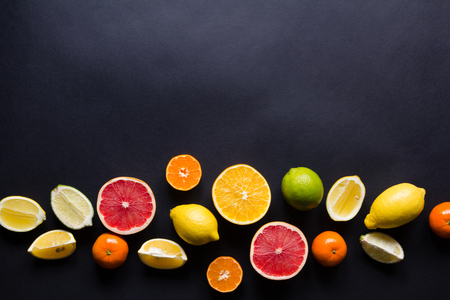 various types of citrus fruit on a dark background. Top viewの写真素材