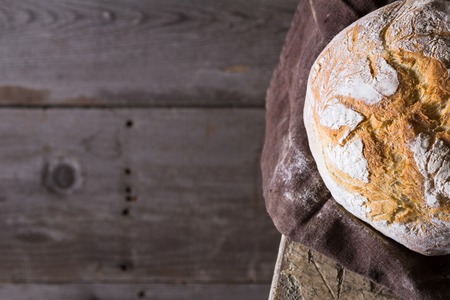 Freshly baked traditional bread on wooden tableの写真素材