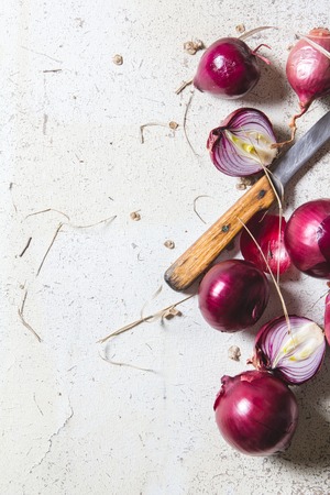 Several kinds of different onion bulbs lying on an old white wooden table. Above view still lifeの写真素材