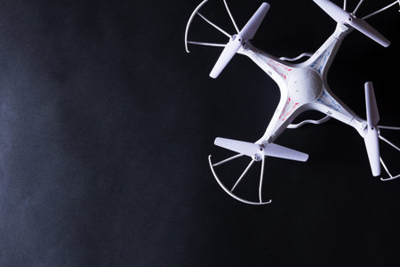 Photo of white quadrocopter on black background. Above viewの写真素材