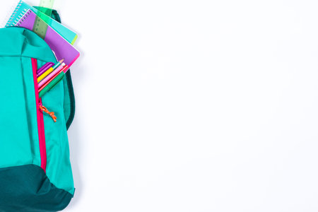 Backpack with school stationery and apple on white backgroundの写真素材