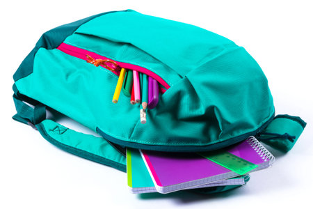 Backpack with school stationery on white background. Close up
