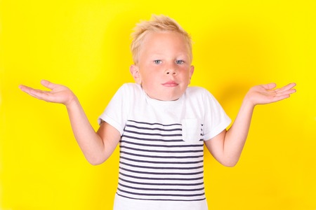 Cute blond boy portrait on yellow backgroundの写真素材