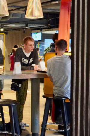 Moscow, Russia - August 2020: Young people dine in the center of Moscow at McDonalds A group of...