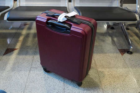 Red Suitcase in Airport Waiting Room Ready for Travel conceptの写真素材