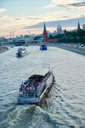 Tourist ship sails on Moskva River past the Moscow Kremlin, Russia. Beautiful view of the Moscow city centre in summer. Scenic panorama of Moscow Kremlin with old churches. High quality photoの写真素材