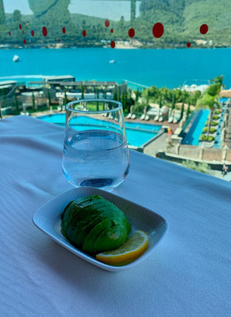 Ketogenic diet breakfast. Avocado, lemon and water, Keto/paleo lunch. Top view of Aegean sea
