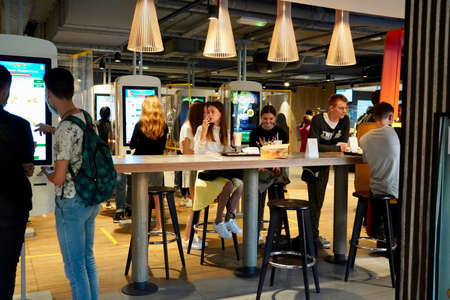 Moscow, Russia - August 2020: Young people sit at a table waiting for lunch at McDonaldsのeditorial素材