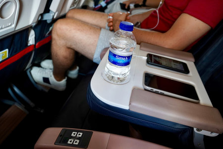 Istanbul, Turkey - August, 2020: A young man on the plane is sitting in business class. A young man...