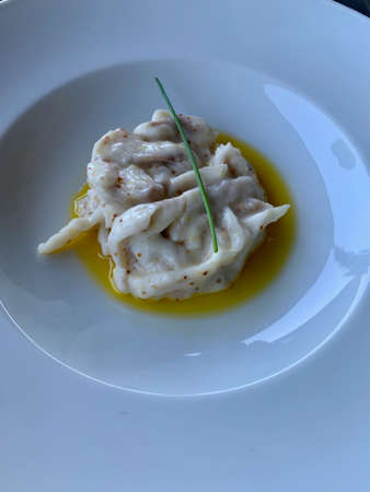 Very tasty delicacies with arugula, seafood, eggs on a plate in the restaurantの写真素材