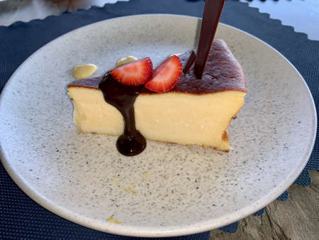 A piece of chocco cake on a plate next to a cup of coffeeの写真素材