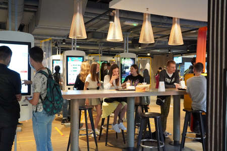 Moscow, Russia - August 2020: Young people dine in the center of Moscow at McDonalds A group of people sitting at a table The place use to meet and dine before going home.のeditorial素材