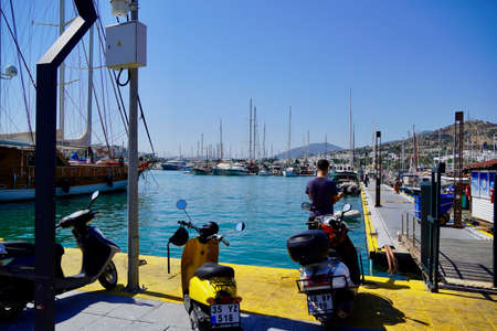 Bodrum, Mugla. Turkey - August, 2020: View of a bay and the marina. Small traditional fishing boats, yachts and gulets.The mountain.のeditorial素材